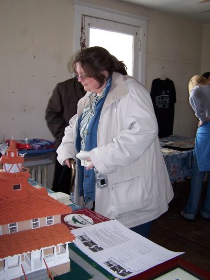 A visitor browses the PLLPS merchandise table